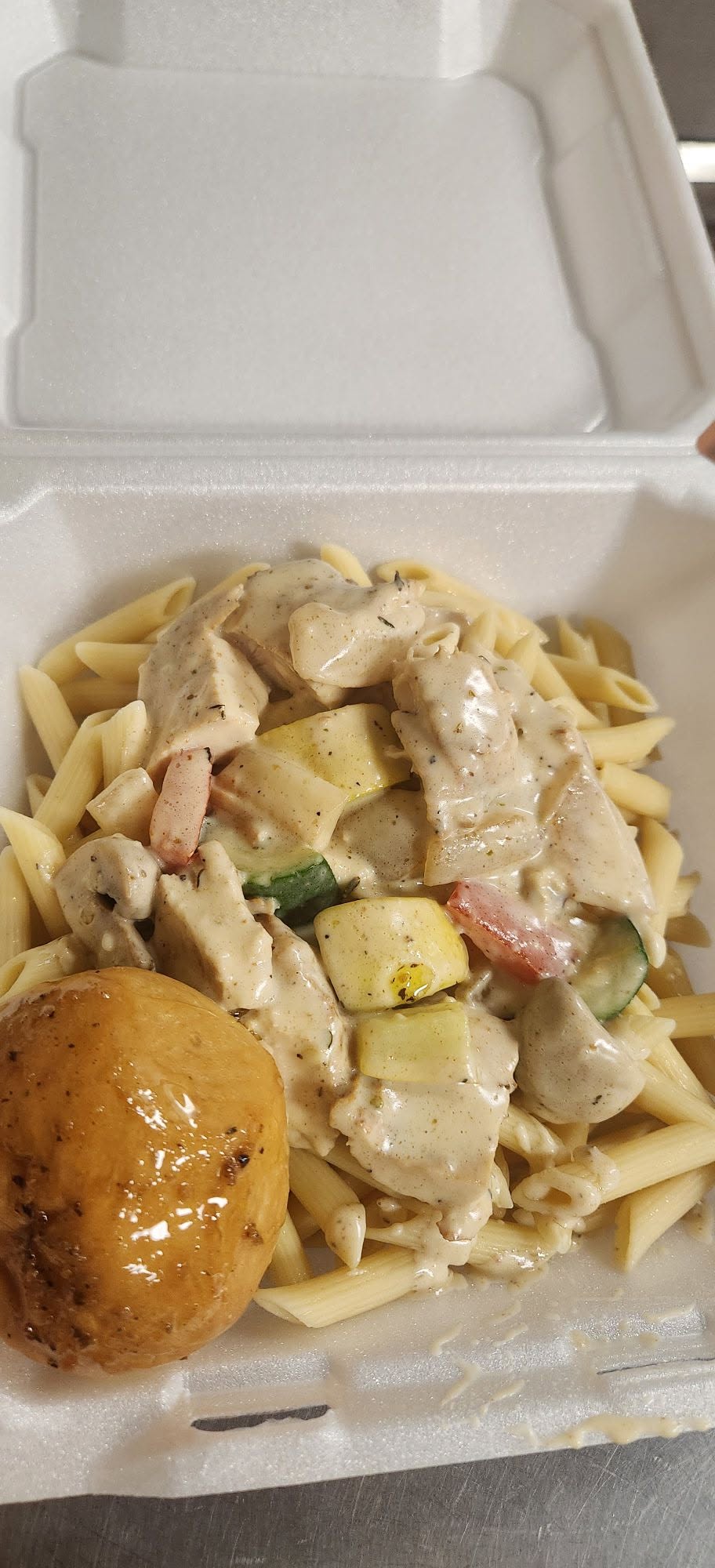 Blackened chicken pasta with vegetables in a to-go box
